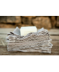 A stack of taupe linen multipurpose hand towels with a soap on top