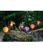 A group of three AMY light objects by Borowski Glass, lit up and set in a natural landscape. Lifestyle image.