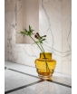 Golden Amber Wavy Glass Vase displayed against white marble surroundings.